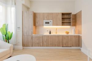 a kitchen with wooden cabinets and a sink at Indulge en Sevilla Faustino 45 in Seville