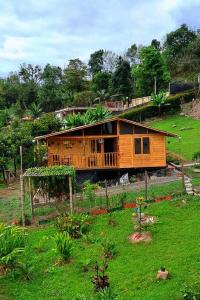 a house sitting on top of a lush green field at Cabaña Caracolí. Tranquilidad vía a la laguna in Ubaque