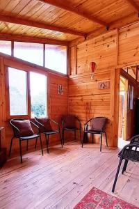 a room with chairs and windows in a cabin at Cabaña Caracolí. Tranquilidad vía a la laguna in Ubaque