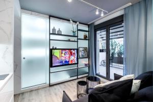 a living room with a tv on a wall at Downtown Boutique Apartments in Athens