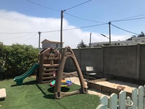 un parque infantil con un tobogán en el patio trasero en No está disponible, en El Tabo