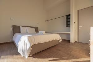 a bedroom with a large bed with white sheets at Villa Theopetra in Theópetra