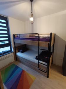 a room with two bunk beds and a rainbow rug at Studio apartman Bjelašnica SAMBA in Bjelašnica