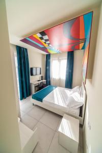 - une chambre avec un lit orné d'un tableau au plafond dans l'établissement HAPPYROOMS, à Bacoli