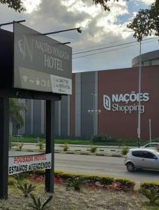 een bord voor een hotel voor een gebouw bij Hotel Pousada em frente ao Nações Shopping in Criciúma