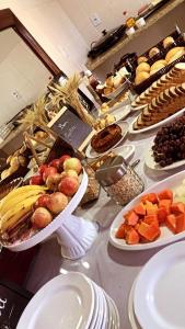 een buffet met veel gerechten op tafel bij Hotel Pousada em frente ao Nações Shopping in Criciúma