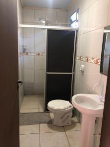 een badkamer met een douche, een toilet en een wastafel bij Hotel Pousada em frente ao Nações Shopping in Criciúma