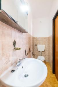 łazienka z białą umywalką i toaletą w obiekcie Villa Pinheiro w Albufeirze