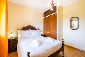 1 dormitorio con 1 cama con 2 toallas en Villa Pinheiro, en Albufeira