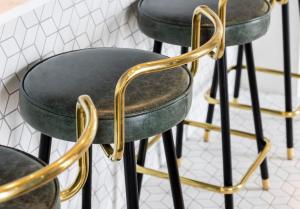 a row of green and gold bar stools at Magnificent Apartments at Ten Degrees in Croydon in Croydon