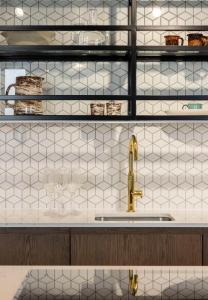 cocina con fregadero y paredes de azulejos blancos en Magnificent Apartments at Ten Degrees in Croydon en Croydon