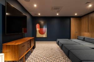 sala de estar con sofá y TV de pantalla plana en Magnificent Apartments at Ten Degrees in Croydon, en Croydon