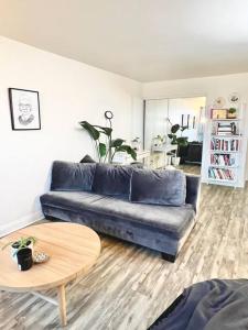 ein Wohnzimmer mit einem blauen Sofa und einem Tisch in der Unterkunft Sunlit Lakeside Oasis in Oakland