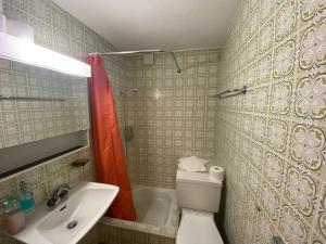 a bathroom with a toilet and a sink and a shower at Hotel Old JNN in Klosters Serneus