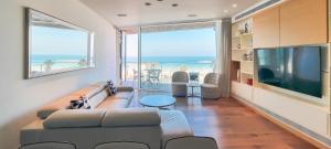 ein Wohnzimmer mit einem Sofa und einem großen TV in der Unterkunft BnBIsrael apartments - Hayarkon Emeraude in Tel Aviv