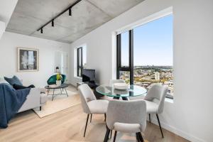 een woonkamer met een glazen tafel en stoelen bij Stunning Stature Southbank 1 bed in Melbourne