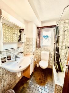 ein Bad mit einem Waschbecken und einem WC in der Unterkunft Hotel Old JNN in Klosters Serneus
