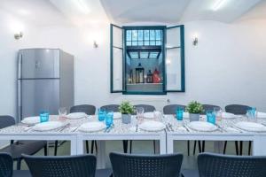 a large white table with chairs and a refrigerator at Magyaros-szecessziós Villa in Budapest