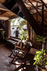 a porch with benches and potted plants on a patio at Hotel Casa Mixteca in Huajuapan de León