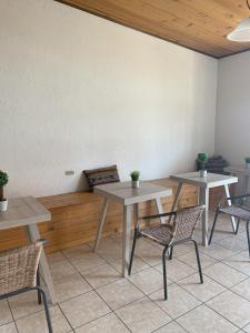 twee tafels en twee stoelen in een kamer bij Inari Hostal in Guatemala
