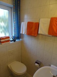 a bathroom with a toilet and a window and towels at Clemens 1 in Wangerooge +3 photos