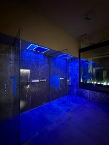 uma casa de banho com um chuveiro com luzes azuis em Magnolia Napoli em Nápoles