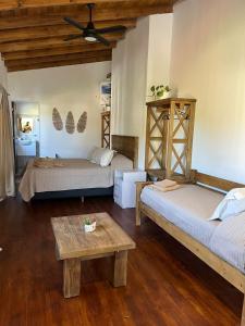 Habitación con 2 camas y mesa. en Algarrobos del Mirador en Santa Rosa de Calamuchita