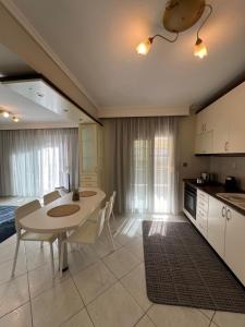 a kitchen and dining room with a table and chairs at Parma’s Pool apartment in Perea