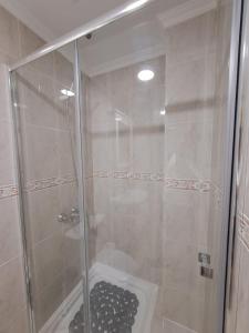 een douche met een glazen deur in de badkamer bij The Home E&N in Gáldar