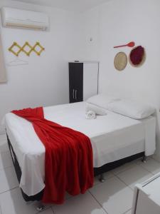 ein Schlafzimmer mit einem Bett mit einer roten Decke darauf in der Unterkunft Mandacaru Flat in São Miguel do Gostoso + 3 Fotos