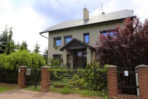 a house with a fence in front of it at 10 Bed And Breakfast in Poznań