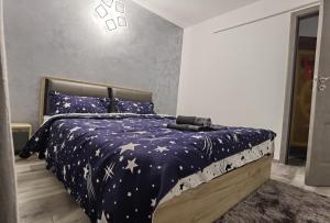 una camera da letto con un letto dotato di un piumone blu con stelle di Apartament Epic H a Gura Humorului