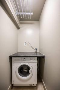 a laundry room with a washing machine and a sink at Dinbnb Apartments I Romantic Surroundings in The City Center in Bergen