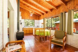 a kitchen and dining room with a table and chairs at Cabañas Rápidos del Río Baker in Puerto Bertrand