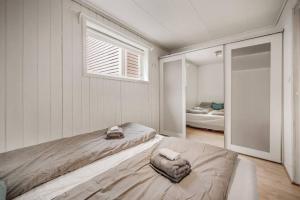 a white room with two beds and a window at Dinbnb Apartments I Romantic Surroundings in The City Center in Bergen