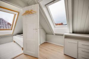 a attic bedroom with a bed and a window at Dinbnb Apartments I Romantic Surrourings in Bergen