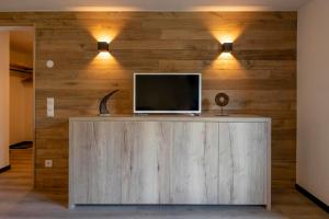 TV en la parte superior de una pared de madera con luces en Drei Türme Top A2, en Schruns