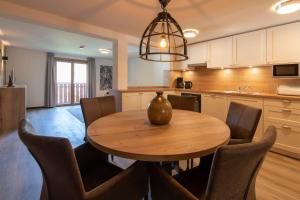 Una cocina y un comedor con mesa y sillas de madera. en Drei Türme Top A2, en Schruns