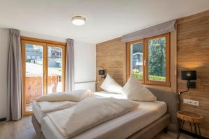 - une chambre avec un grand lit et des oreillers blancs dans l'établissement Drei Türme Top A4, à Schruns