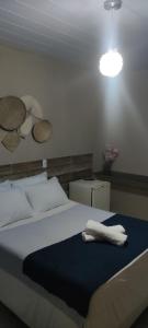 um quarto com uma cama com um cobertor azul e uma luz em Pousada Nordestina no Recife