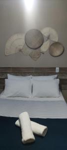 un letto con cuscini e piatti bianchi appesi al muro di Pousada Nordestina a Recife