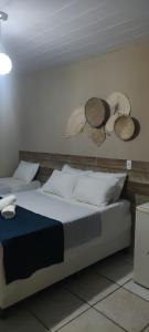 sypialnia z dwoma łóżkami i kapeluszami na ścianie w obiekcie Pousada Nordestina w mieście Recife