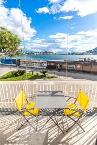 d'une table et de chaises sur un balcon avec vue sur l'eau. dans l'établissement HAPPYROOMS, à Bacoli