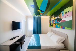 ein Schlafzimmer mit einem Bett, einem Schreibtisch und einem Gemälde in der Unterkunft HAPPYROOMS in Bacoli