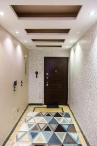 a hallway with a black door and a tile floor at A Family Friendly Apartment in Cairo