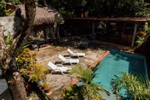 a swimming pool with lounge chairs and a house at Hostel Villa Vento Surf in Santa Catalina