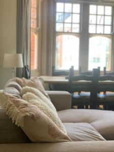 ein Wohnzimmer mit einem Sofa, einem Tisch und Fenstern in der Unterkunft Lovely 4 bedroom home, stones throw from the beach in Brighton & Hove