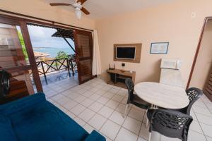 a living room with a table and chairs and a television at Apartamentos Natal Ponta Negra Vista Espetacular para o Mar in Natal