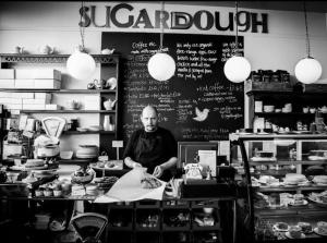 a man standing behind a counter in a kitchen at Lovely 4 bedroom home, stones throw from the beach in Brighton & Hove