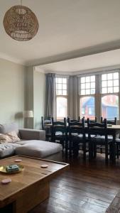 a living room with a couch and a table and chairs at Lovely 4 bedroom home, stones throw from the beach in Brighton & Hove